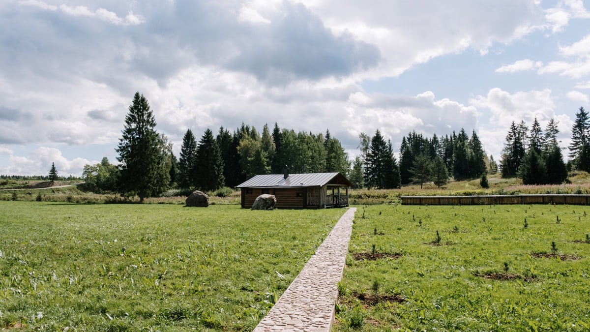 A scenic view of a countryside house surrounded by lush greenery and clear skies.