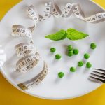 Diet white plate with centimeter peas and basil