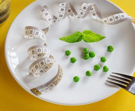Diet white plate with centimeter peas and basil